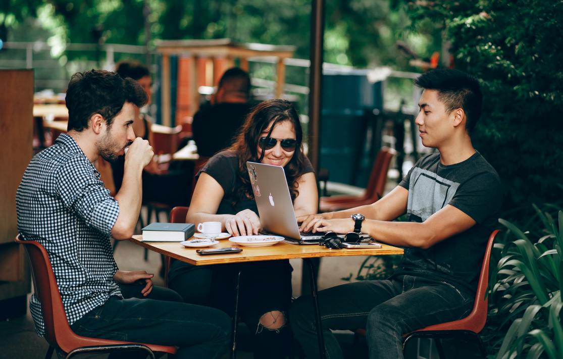 Group of people meeting outside around a table